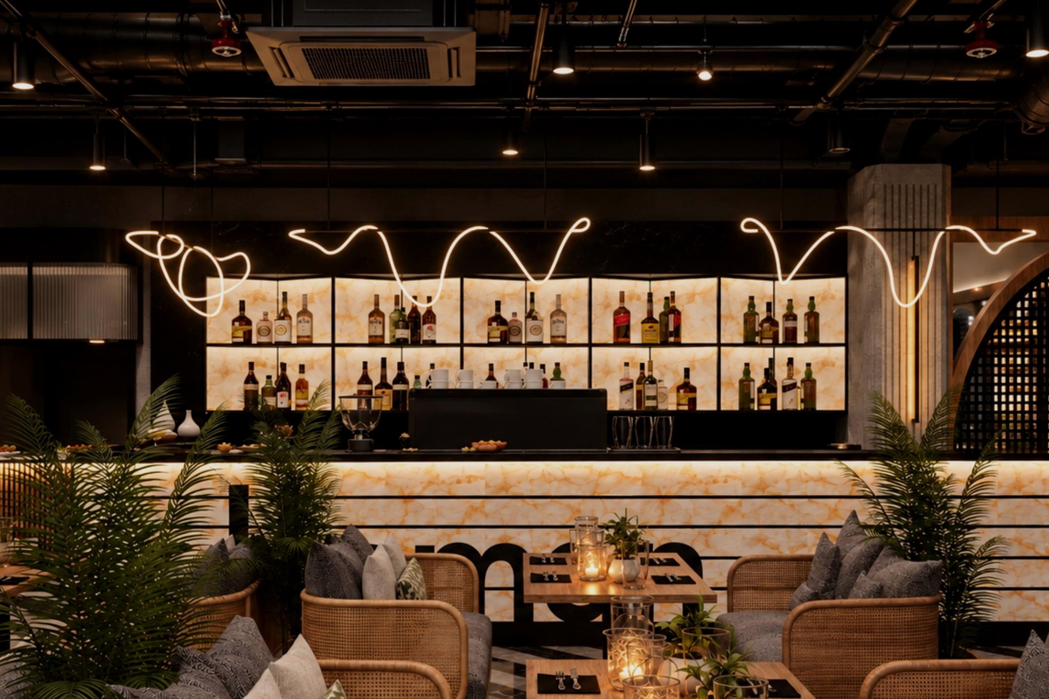 De bar van Ottoman Amsterdam — verlichte natuurstenen barwand, flessenrekken en een golvende lamp